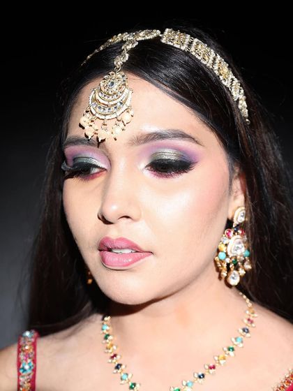 A detailed close-up of the eye makeup for the pink lehenga look. This showcases a multi-toned smokey eye with shades of black and purple, a technique that adds depth and drama.