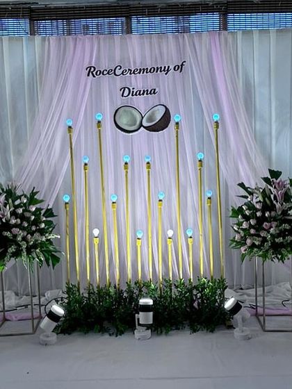 Another view of the Roce Ceremony stage, highlighting the soft lighting and the symmetrical arrangement of the floral bouquets.