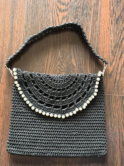 Another must-have for your collection, this black crochet bag features beautiful pearl detailing along the flap. The intricate openwork design makes it a versatile and elegant choice.