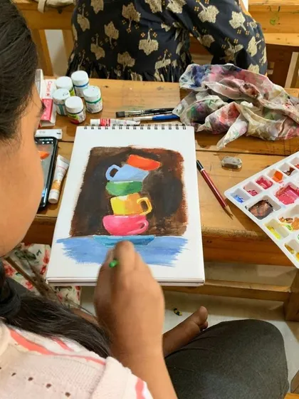 A student adds details to her vibrant acrylic painting of teacups. Our classes encourage students to play with color and develop their own unique style.