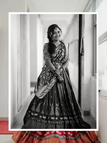 A classic black and white portrait of a bride in a traditional half-saree, capturing her timeless beauty.