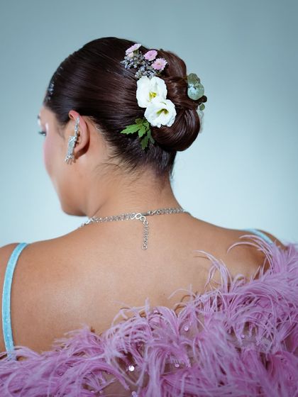 A detailed shot of the beautiful floral hair bun created for Sakshi Sindwani's candy-colored dreamland look.