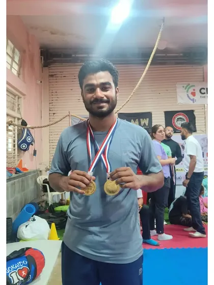 A champion's smile. One of our senior athletes proudly displays his two gold medals after a dominant performance at the district championship.