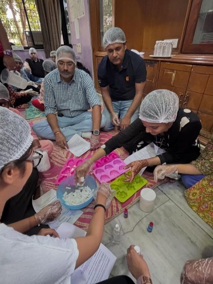 A closer look at the participants as they mix their soap bases and prepare to add colours. This shows the collaborative and focused atmosphere of the workshop.