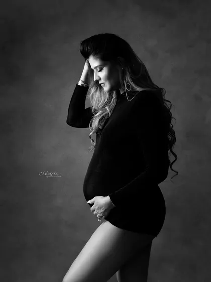 Grace in its purest form. This monochrome portrait focuses on the quiet, contemplative moments of pregnancy, highlighting the beauty of the female form.