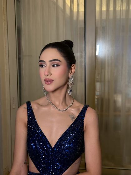 A side profile showcasing the clean lines of the makeup and the elegant updo. The focus is on creating a polished and sophisticated silhouette.