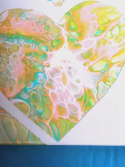 A close-up detail of a heart-shaped fluid art piece. The intricate cells and color blending show the delicate and surprising nature of this technique.