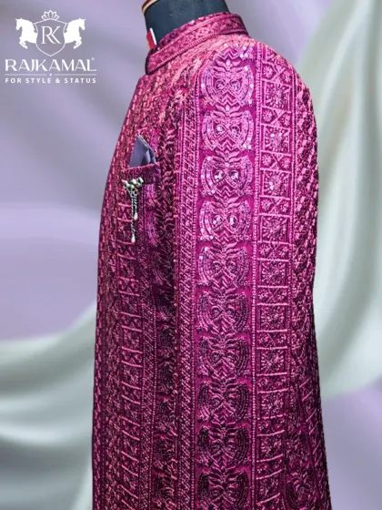 A side view of a magnificent magenta Jodhpuri suit, featuring dense, tone-on-tone embroidery. This piece is paired with a long inner shirt for a modern, layered look.