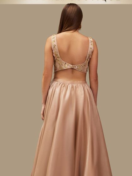 It's all in the details. The stunning open-back design of our champagne gold lehenga blouse adds a touch of modern allure to a classic silhouette.