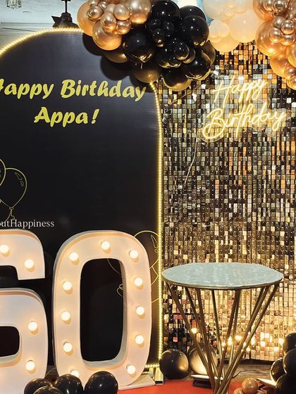 A close-up of our 60th birthday setup for 'Appa', featuring a sleek black arch, a shimmer wall, and bold light-up numbers.