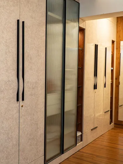 This wardrobe holds a clever secret. I designed it with a hidden, tucked-in pouf that can be pulled out for a comfortable seat at the vanity, making it a perfect example of smart, space-saving design.