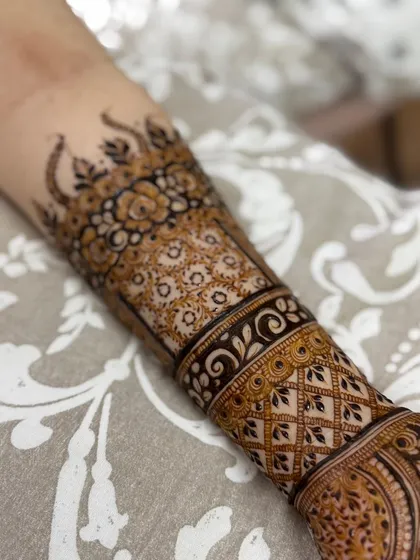A close-up on the forearm portion of the design, highlighting the floral and geometric bands.