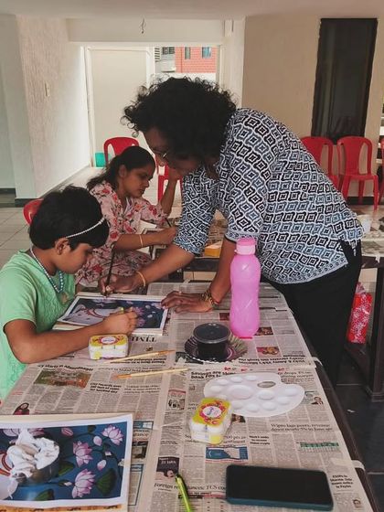 Individual attention is key, even in a group setting. I'm providing one-on-one guidance to a young artist at our outdoor Pichwai painting session.