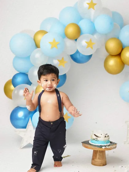 The aftermath! Covered in cake and happy about it, the birthday boy shows off his messy hands. These are the fun memories we love to capture.