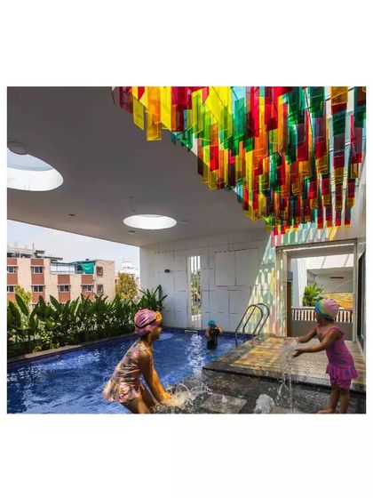 The swimming pool area at the 'Toy Story' preschool features a colorful acrylic installation on the ceiling. This casts vibrant, shifting colors onto the water, making it a magical place for children.