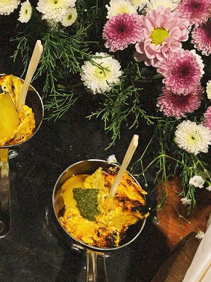 A close-up of our Paneer Tikka, showing the char-grilled texture and the vibrant green chutney. We pay close attention to how our food is cooked and presented, ensuring it's delicious and visually appealing.
