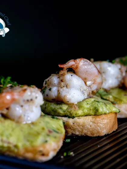 A sophisticated seafood appetizer. This Guacamole Prawn Bruschetta features perfectly grilled prawns on a bed of fresh, zesty guacamole, served on a crisp toast. It's a perfect starter for a sundowner or an elegant brunch.