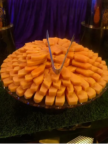 A large platter of sliced papaya, showcasing the abundance and quality of our fruit selection.