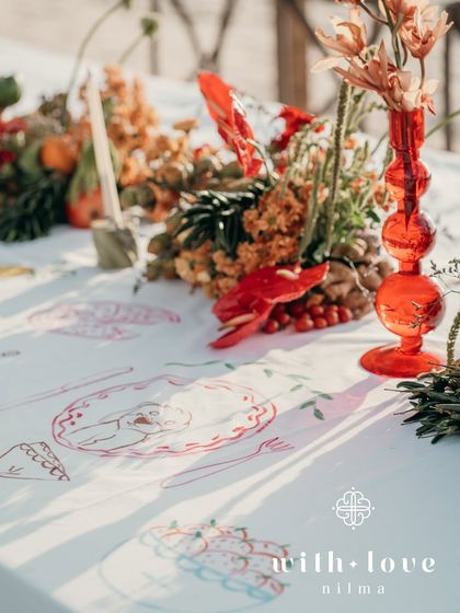 A close-up of our interactive table overlay, where guests could paint illustrations that told the couple's story. This unique detail, combined with the vibrant floral and fruit decor, made for a truly personal and engaging event.
