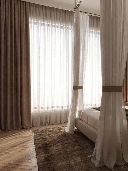The large window is dressed in layers of curtains, allowing for control over the natural light that fills the room.