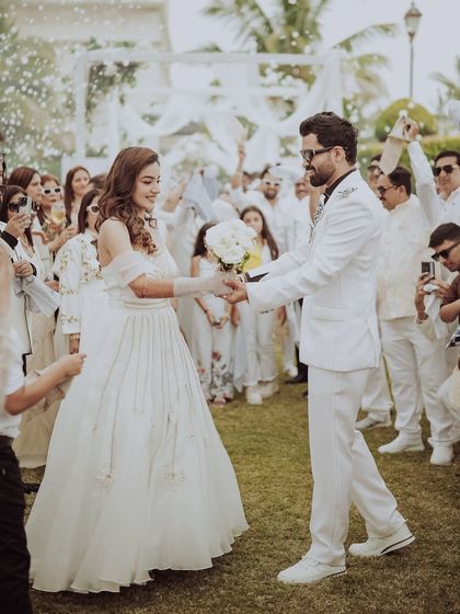 A dance to begin the festivities. The groom takes his bride's hand for a dance, surrounded by guests, kicking off the afternoon gala with elegance and joy.