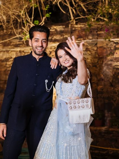 A happy, celebratory portrait of a newly engaged couple, with the bride proudly showing off her ring.