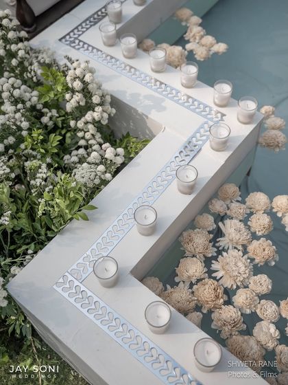 Every detail of this Ivory wedding feels like a dream. Here, floating flowers and candles in the water feature add to the ethereal and thoughtfully curated ambiance.