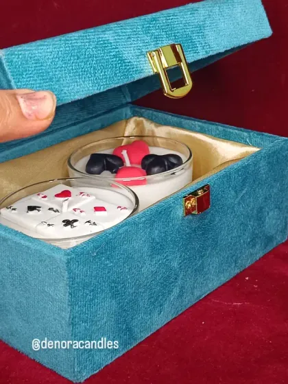 The poker candle gift set in its teal velvet box, shown being opened.