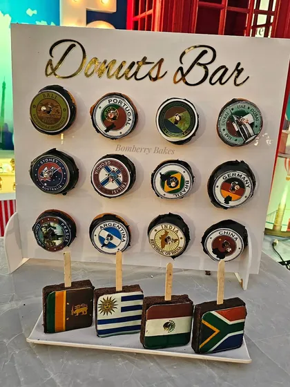 A donut bar with donuts and brownie pops featuring different country flags and travel logos.
