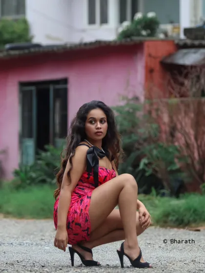 A bold, low-angle shot of a model in a pink and black mini-dress. The pose is strong and dynamic, perfect for a high-fashion or street style look.