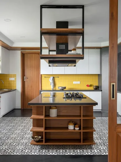A kitchen should be full of life, and this island kitchen from 'Vasudhalayah' is just that. The bold yellow piccolo tile backsplash and Moroccan floor tiles create a vibrant energy, while the custom island with an integrated hob and overhead unit provides a highly functional culinary workspace.
