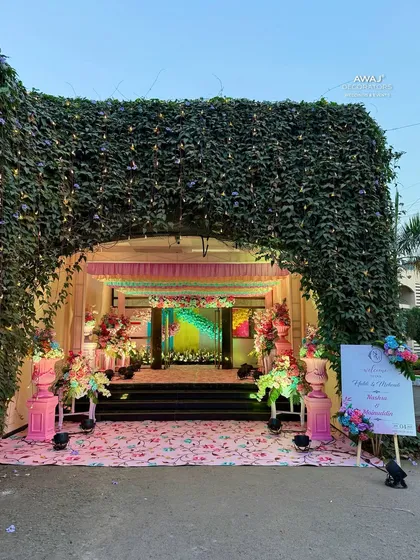 A grand entrance arch made of natural ivy, leading into the pastel-themed celebration.