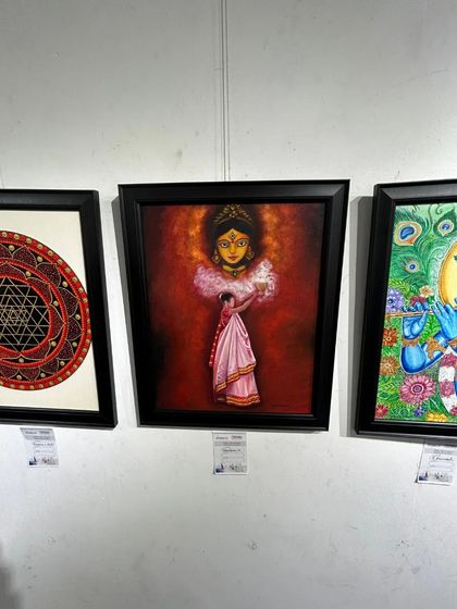 The same painting, "The Worshipper of Durga," beautifully framed and displayed at an exhibition, showcasing its gallery-ready quality.