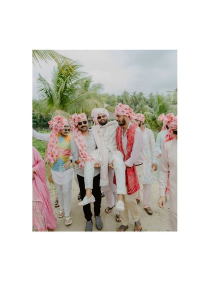 A fun, candid moment from the Baraat, with the groom being carried on the shoulders of his friends.