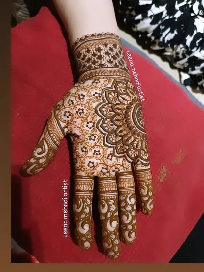 A close-up of a detailed mandala design. The pattern is a beautiful mix of a central mandala with floral and paisley elements filling the rest of the palm.