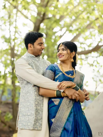 A lovely portrait of the newly engaged couple, Sahana and Bhuvan, sharing a happy embrace outdoors.