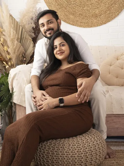 A smiling portrait of the couple seated together. This shot captures their happiness and excitement in a relaxed and natural pose.