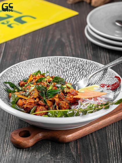 A close-up of the Mutton Ulayarithatu, a dry-fried mutton dish with rich spices and curry leaves. A true taste of South India.