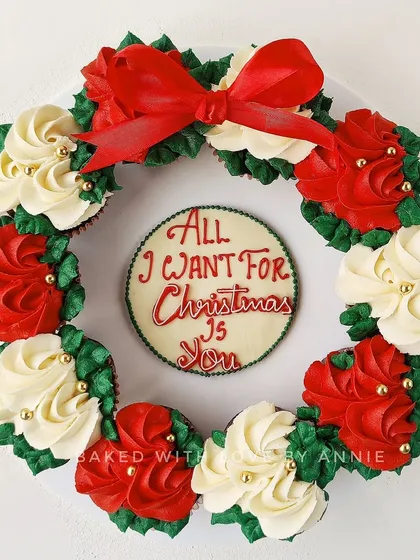 My Christmas Cupcake Wreath, a beautiful and edible centerpiece. It features a circle of my Belgian chocolate cupcakes decorated in festive red, white, and green buttercream.