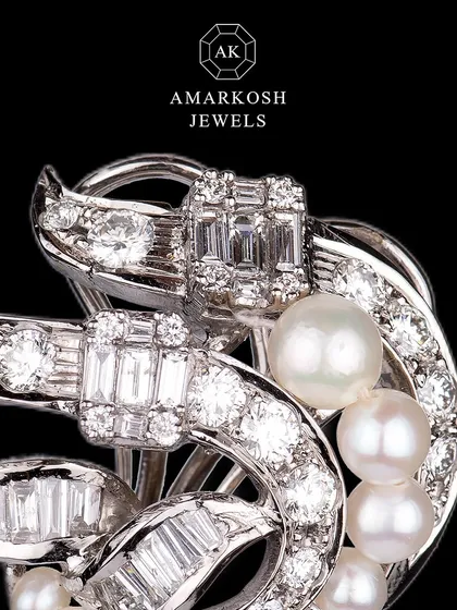 These breathtaking earrings feature an intricate design of natural round diamonds, baguette diamonds, and natural pearls, embodying luxury and elegance.