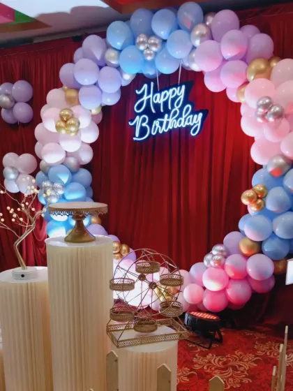 A close-up of the pastel balloon ring against the rich red backdrop.