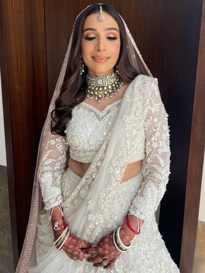 A beautiful bride in a stunning white lehenga. I styled her hair with soft waves and a center part to complement her maang tikka.