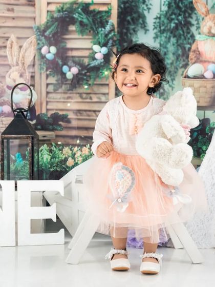 Celebrating turning one with a simple, elegant setup. The 'ONE' letters and her pretty dress are all that's needed for a beautiful milestone photo.