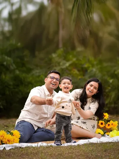A family enjoying a sunny day in the park. Outdoor sessions allow for natural, candid moments of laughter and play, surrounded by vibrant sunflowers.