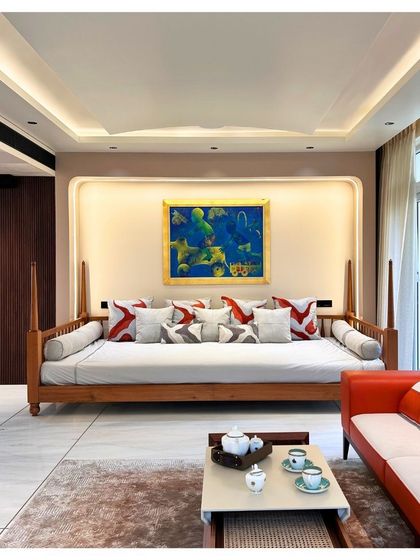 We created a modern 'baithak' or family seating area in the Palm Springs Villa, featuring a classic wooden daybed. This space is designed for informal gatherings, blending traditional Indian living concepts with contemporary aesthetics.