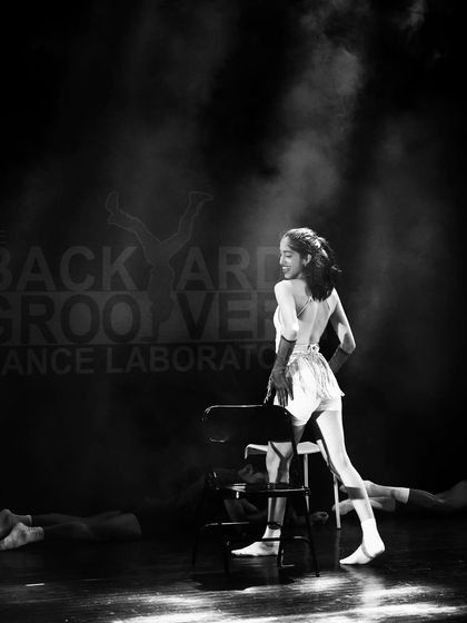 A classic black and white shot capturing the elegance and attitude of Jazz dance. This moment from a chair-based routine highlights the strong lines and expressive poses we teach in our Broadway and Jazz choreography.