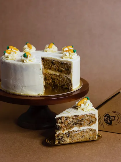 A slice of pure comfort. My classic carrot cake features an aromatic, moist sponge layered with a zesty cream cheese frosting. It's a timeless favorite that I've perfected for my everyday menu.