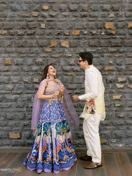 A moment of shared laughter between the bride and groom, their vibrant and quirky outfits perfectly matching the fun carnival theme.