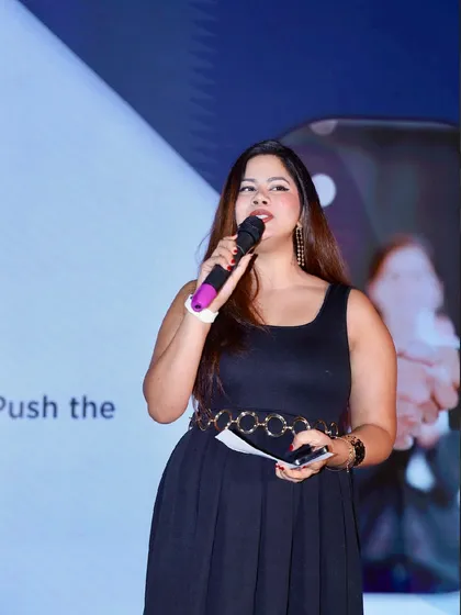 A focused shot during a corporate event. Holding the mic and my notes, I'm in my element, guiding the audience through the evening's agenda.