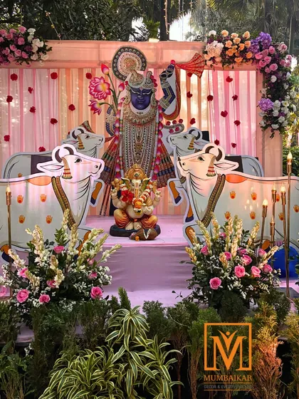 A full view of the Krishna-themed wedding stage. The decor combines traditional motifs with fresh flowers and elegant draping, creating a sacred and beautiful space for a wedding ceremony.